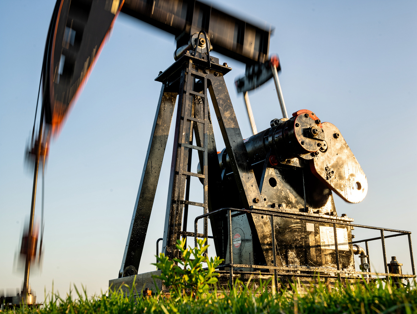 Oil pumpjack silhouette against an energy sector sunset